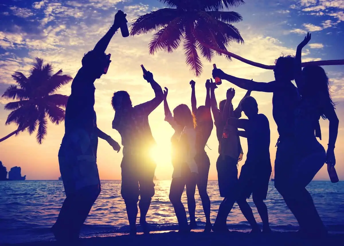 People dancing at a beach party at night.