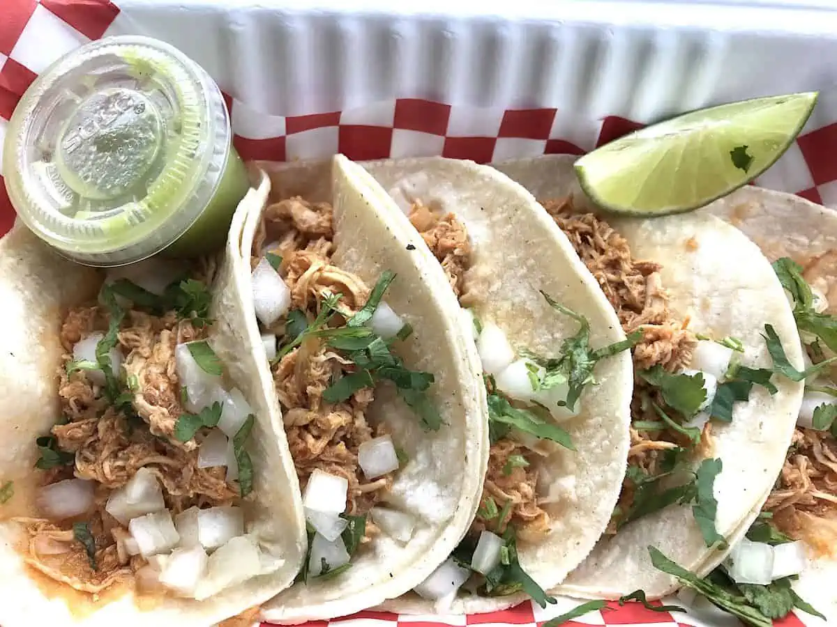 Tacos on corn tortillas with a checkered napkin.  