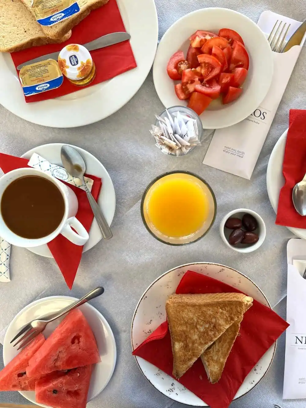 A breakfast in Greece of melon, coffee, toast and kalamata olives.  