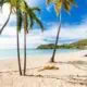 Carlisle bay beach with white sand, turquoise ocean water and blue sky at Antigua island in Caribbean