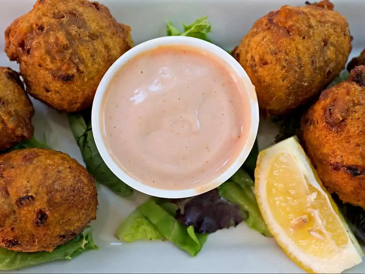 Conch Fritters on plate with sauce. 