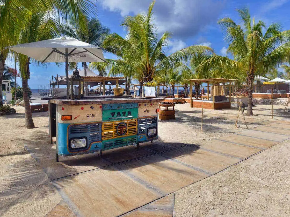 Outside tables on the beach with Palm trees.