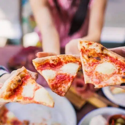 People on a food tour eating pizza.